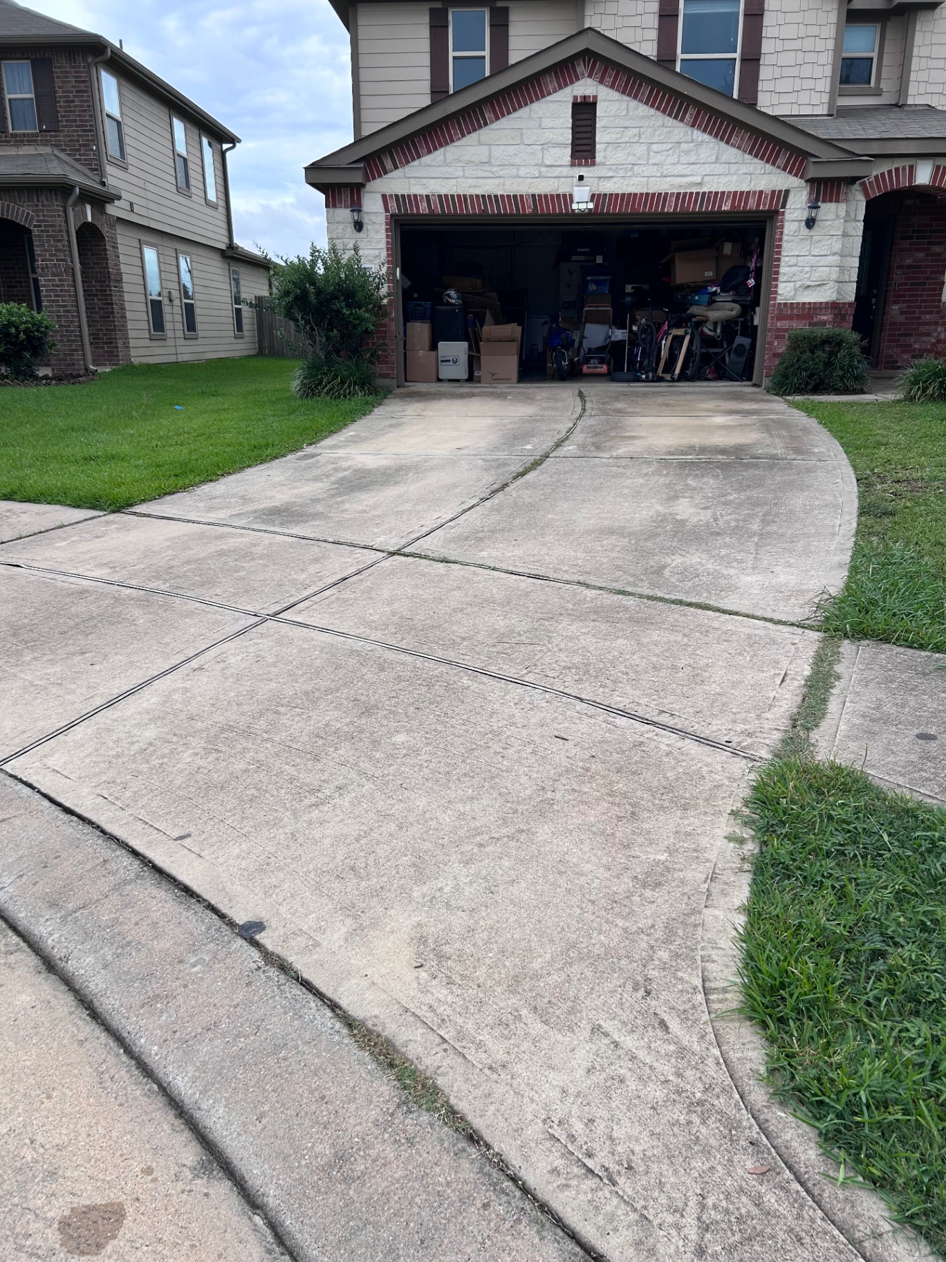 Concrete driveway being pressure washed to remove grime at a Cypress, TX home by Rose Power Washing